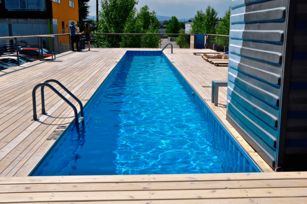A shipping container pool with a deck around it.