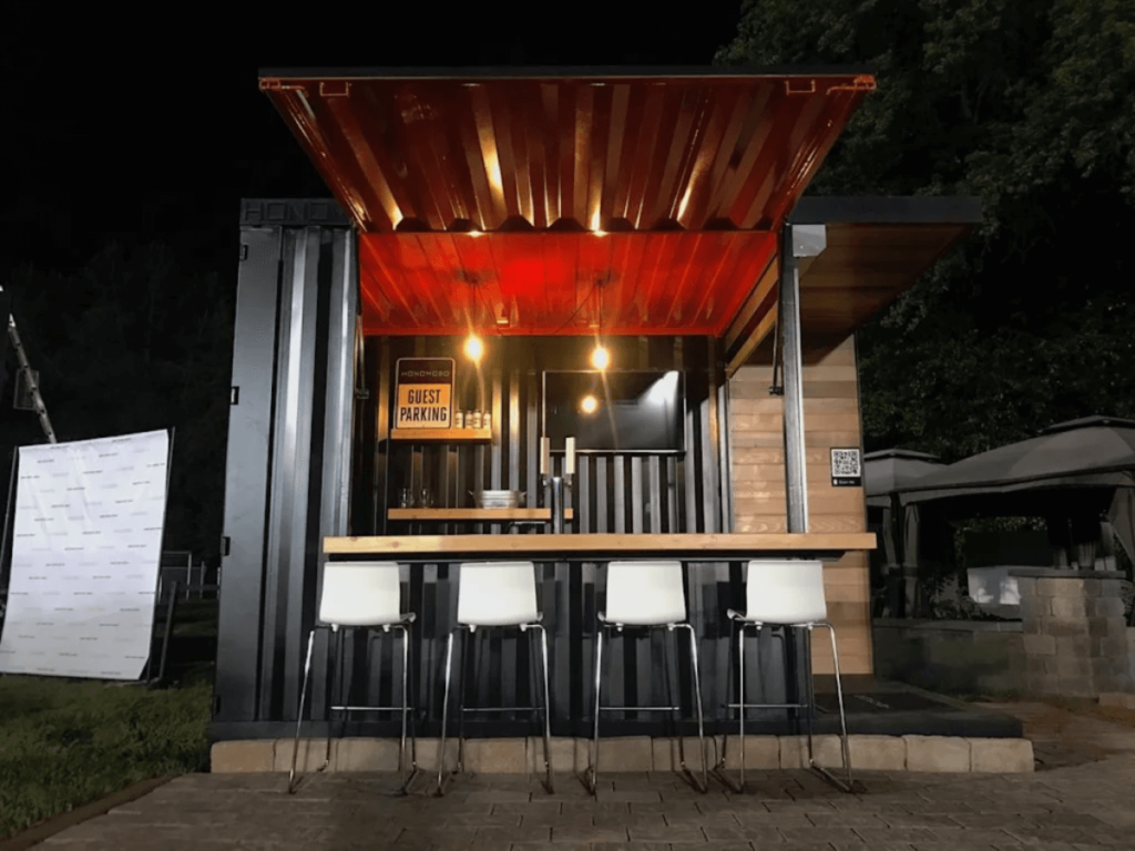 A small shipping container bar area with 4 bar stools. 