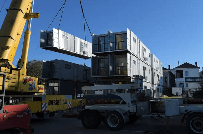 Shipping containers being assembled together to create a new construction.