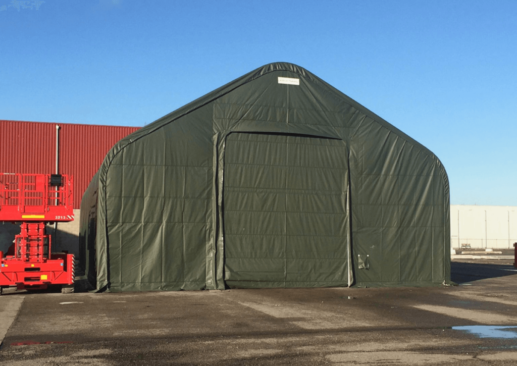 a storage tent next to a larger building or warehouse