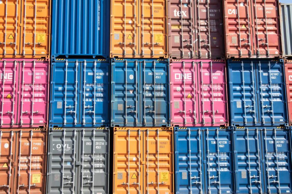 A colorful wall of shipping containers stacked on top of one another.