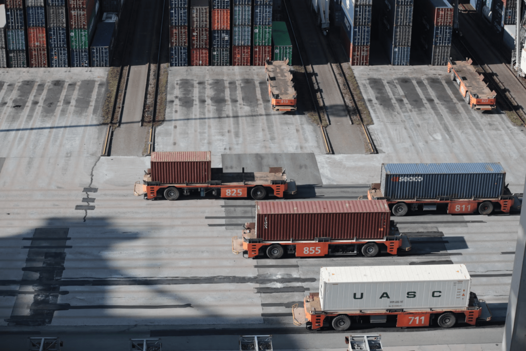 A yard full of shipping containers getting ready for freigh shipping.