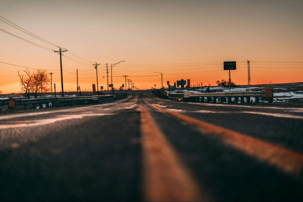 A view of a highway with mostly empty fields around it.