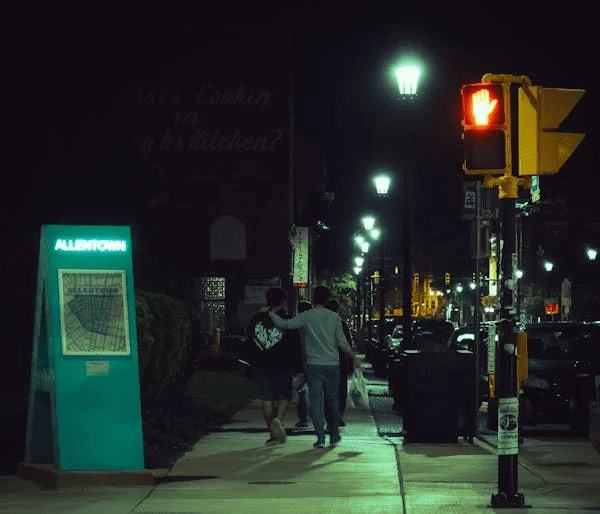 A steet at night with a restaurant in the background