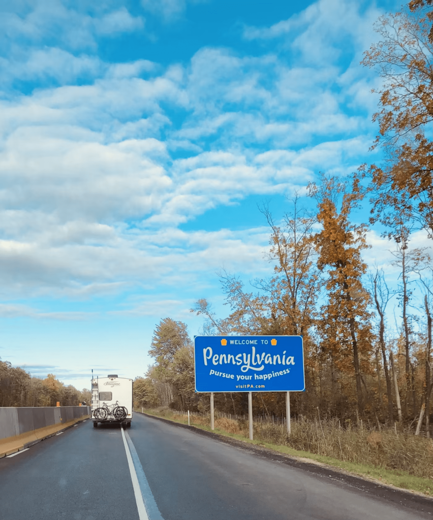 A highway with the 'Welcome to Pennsylvania' sign on the side of the road