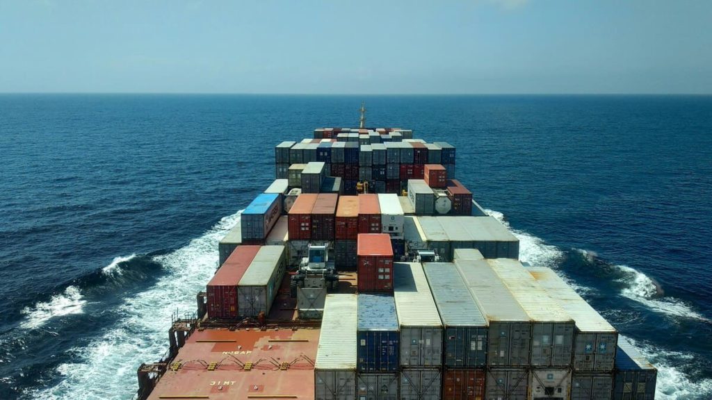 A bunch of storage containers loaded on a ship that is at sea