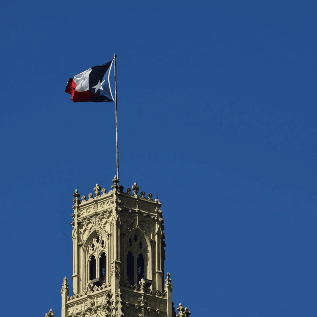 The texas flag flying atop a building in San Antonio