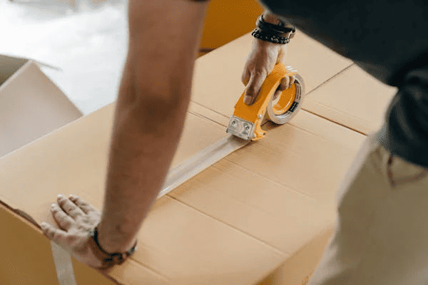 A man taping shut a box to put into storage