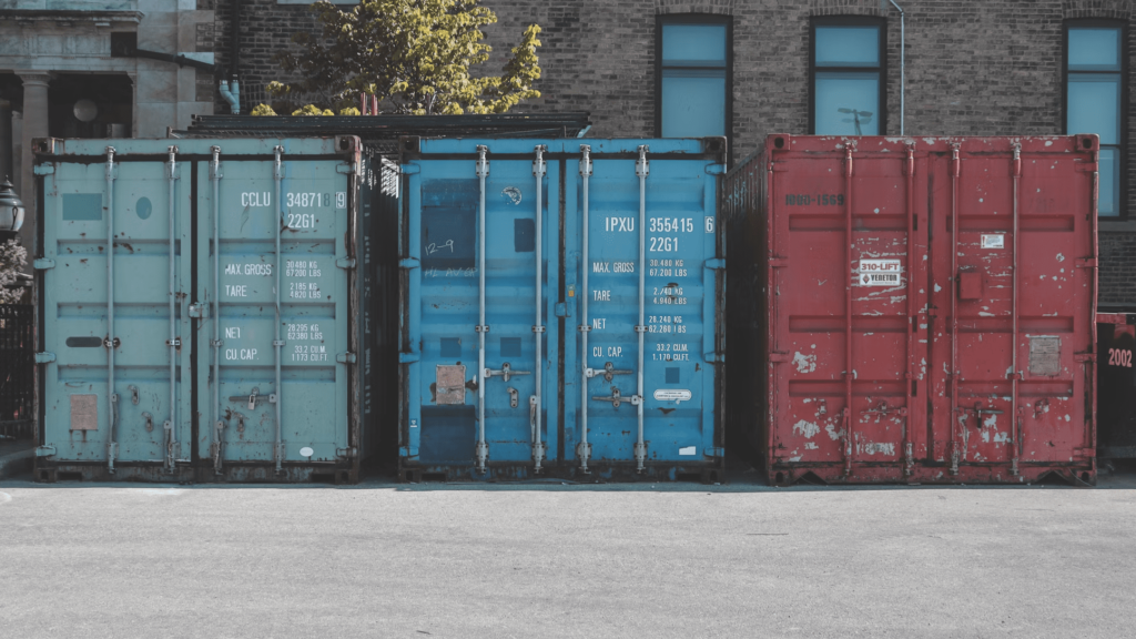 3 storage containers sitting outside of buildings