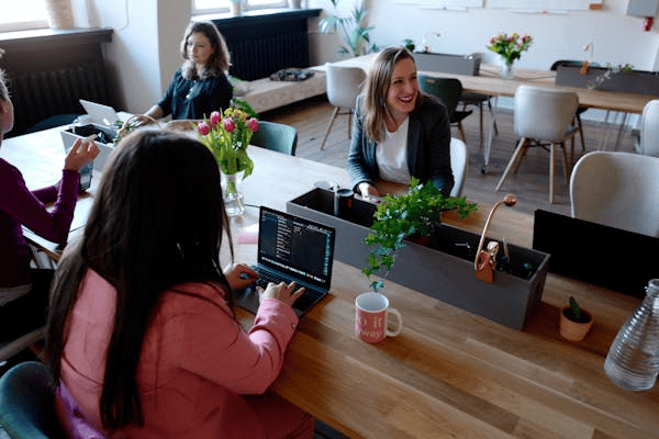 Employees at a conference table inside a workspace.