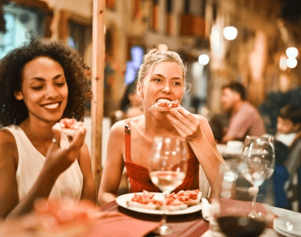 women eating a flatbrread in a nice restaurant