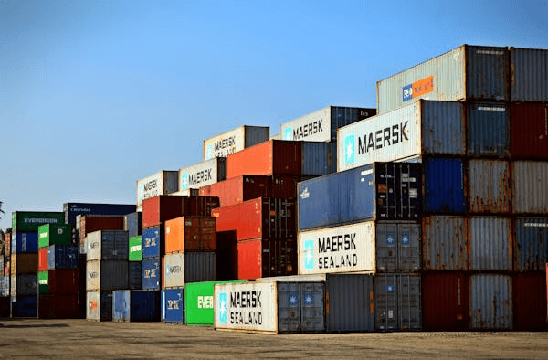 shipping containers piled up in a storage yard