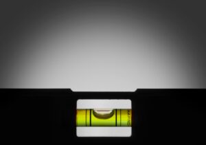 Close-up of a spirit level bubble centered between black lines, showing a perfectly level surface.